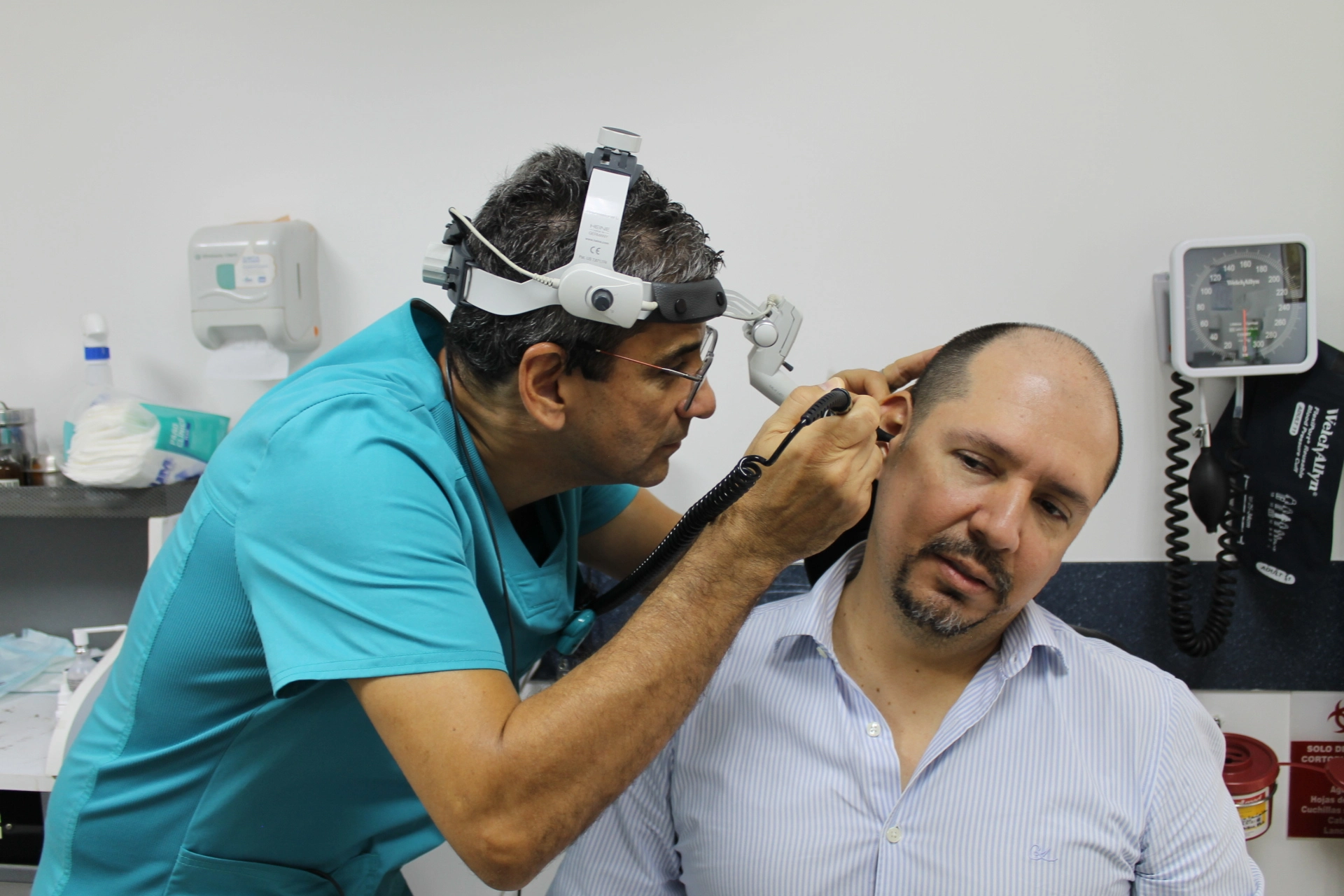 Doctor usando tecnología avanzada para revisar el oído de un paciente durante consulta médica