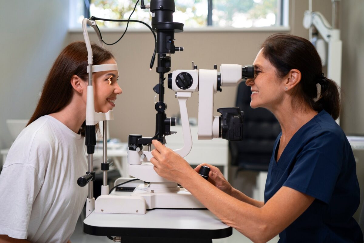 Examen visual con lámpara de hendidura entre optometrista y paciente.